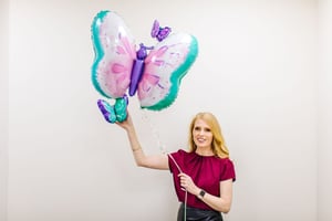 Marie-Claire Ross holding a balloon for the Executive Coaching Services page