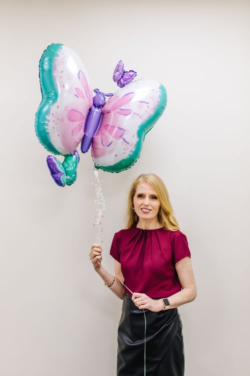 leadership-coach holding a butterfly balloon