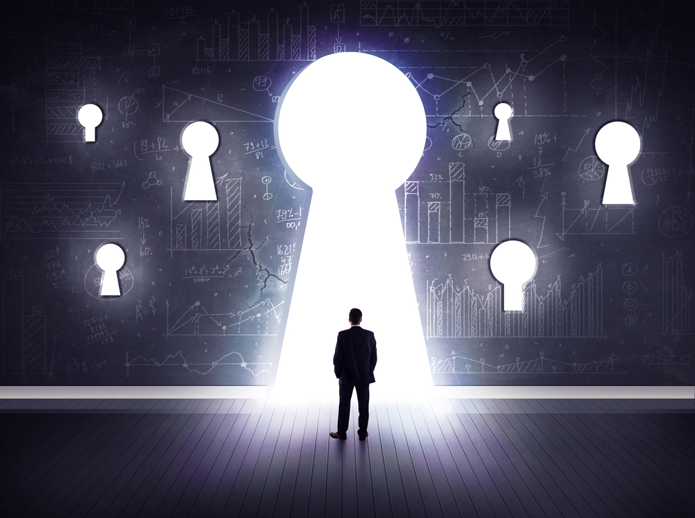 Successful businessman looking through keyhole Successful businessman looking through keyhole